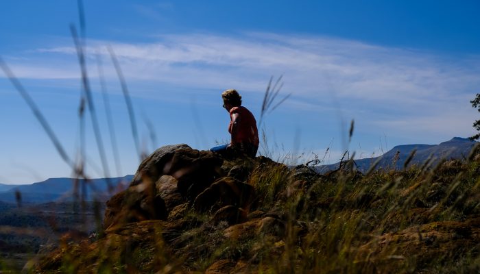 solo hiker sitting on karoo hill in sunshine
